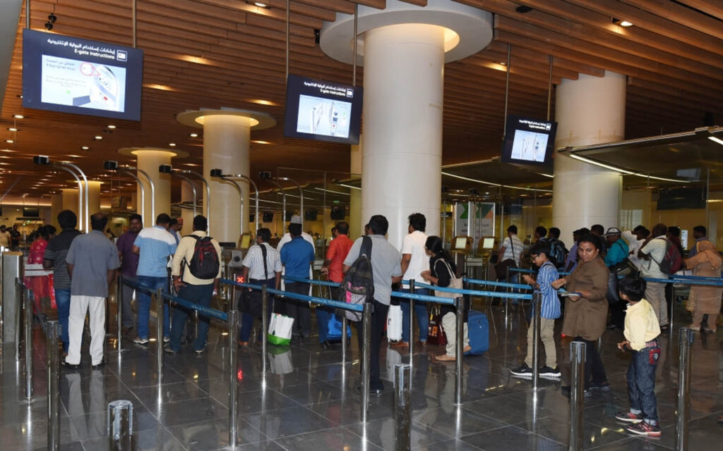 Muscat International Airport terminal with passengers moving through the boarding pass area