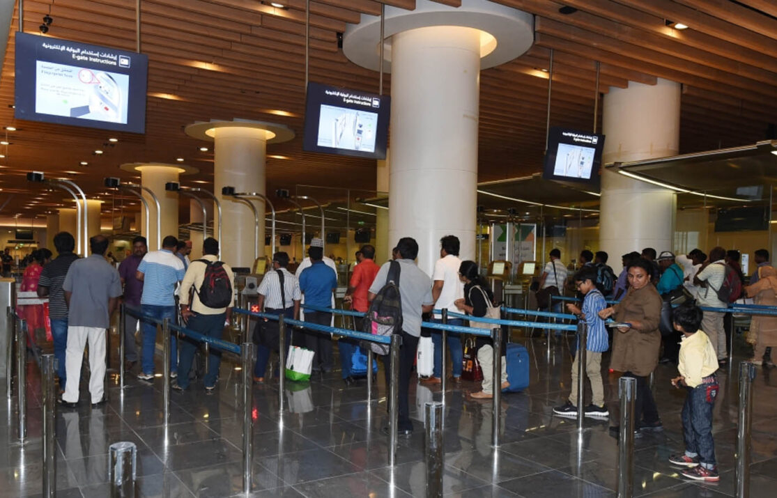 Muscat International Airport terminal with passengers moving through the boarding pass area