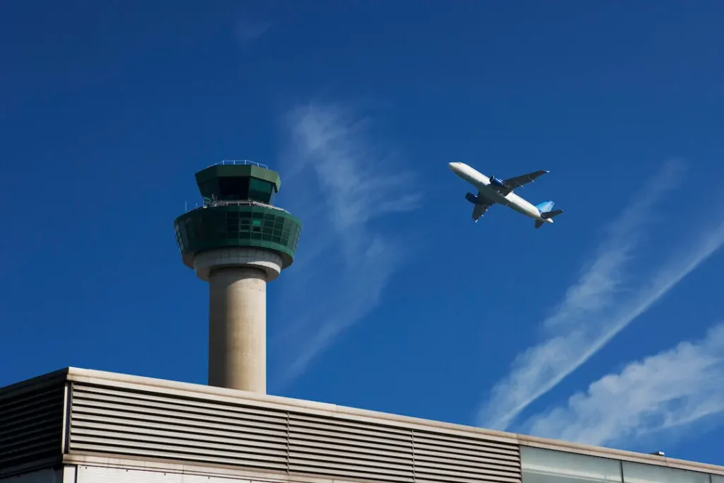 Image of an aircraft passing over a traffic control tower