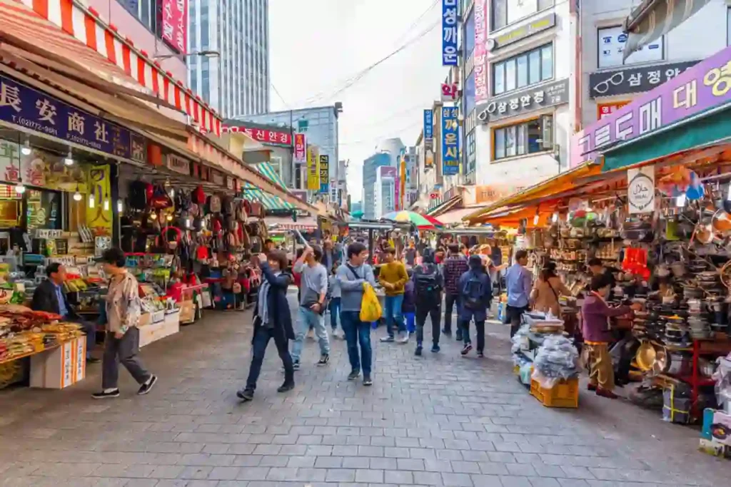 A vibrant street in Seoul with bustling crowds, colorful shops, and a peaceful ambiance, symbolizing normalcy and tourism activity.