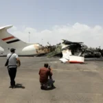 A dramatic image of an airport runway in flames or an aerial view of a damaged airport.